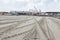 Tire tracks of a big vehicle are on the sand in direction of building site