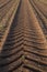 Tire tracks of a heavy harvester in brown earth