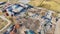 Tire tracks in mud at deconstruction site with piles of steel and iron scrap metal