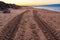 Tire tread marks on sand by sea