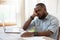 Tired african american man sleeping in front of computer.