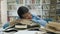 Tired african female student girl lying on the books after long studying in the library