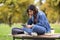 Tired Arab Student Woman Using Digital Tablet While Sitting On Bench Outdoors