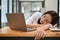 Tired Asian businesswoman falls asleep or takes a nap at her office desk