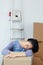 Tired Asian Woman Sleeping on Box after Moving