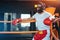 Tired athletic sport man boxer resting in corner boxing ring after fighting