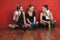 Tired Ballet Dancers Sitting Together On Hardwood Floor