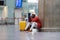 Tired Black tourist man on a long night connection at airport, waiting for plane sitting in terminal