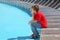 Tired boy sits on edge of deck-chair