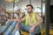 Tired building workers in yellow vests sitting on boards, one of men holding his helmet in his hand