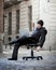 Tired Business Man sitting on Office Chair on Street sleeping