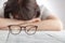 Tired businesswoman falling asleep at her workplace with eyes glasses, The Business Women feel discouraged Holding glasses