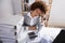 Tired Businesswoman Sitting In Office With Stack Of Files