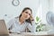 tired businesswoman sitting at table with paperwork laptop