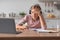 Tired busy european youngsters girl blonde in headphones studying at home at table with laptop