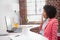 Tired casual businesswoman sitting at desk