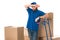 tired delivery man standing between cardboard boxes and looking away