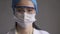 Tired doctor on gray background. Asian woman looking at camera. Abstract defocused image in motion