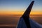 Tired evening sun is hiding behind the wing of the plane before