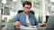 Tired exhausted businessman office worker sits at his desk reading documents.