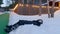 Tired exhausted teenage girl lies on snow and rest near wooden fence with yellow lights in cottage village at evening