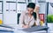 Tired and exhausted woman looks at the mountain of documents. Deadlines for the submission of reports.