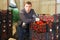 Tired farmer leaning on boxes with tomatoes in greenhouse