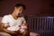 Tired Father At Home Cuddling Twin Baby Daughters In Nursery