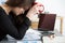 Tired female employee at workplace in office holding cup of tea