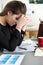 Tired female employee at workplace in office holding cup of tea