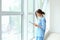 Tired female nurse near window in hospital