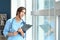 Tired female nurse near window in hospital