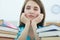 Tired female student at workplace in room taking nap on pile of textbooks. Sleepy brunette woman resting during