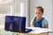 Tired girl schoolgirl sits in front of a laptop and looks sadly at homework. Distance learning