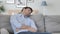 Tired Handsome Young Man Sleeping while Sitting on Couch