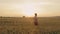 Tired, hardworking farmer going, walking on filed with wheat.