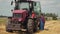 Tired hardworking farmer in overalls near a modern energy-saturated tractor