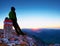 Tired hiker sit on border stone on Alps mountain. Austria Germany border. Daybreak above foggy valley