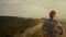 Tired jogger running in mountain landscape. Smiling guy raising hands outdoor