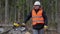 Tired lumberjack near chainsaw in forest