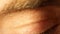 Tired man`s eye with red capillaries and eyelashes close