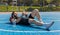 Tired man in sportswear after playing basketball game lying down on ball relaxing using smartphone