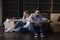 Tired married couple sit on floor near cardboard boxes