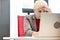 Tired mature businesswoman using laptop at desk in office