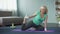 Tired mature woman doing yoga exercises, stretching legs. Healthy lifestyle