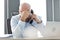 Tired mid adult businessman using landline phone at desk in office