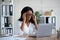 Tired millennial black businesswoman suffering from terrible headache at desk in office