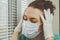 The tired nurse closed her eyes. Medical professional in a surgical protective mask is tired after a shift during a