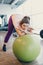 Tired Obese Woman Leans on gym ball in gym