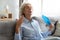 Tired older woman waving fan, suffering from heat at home